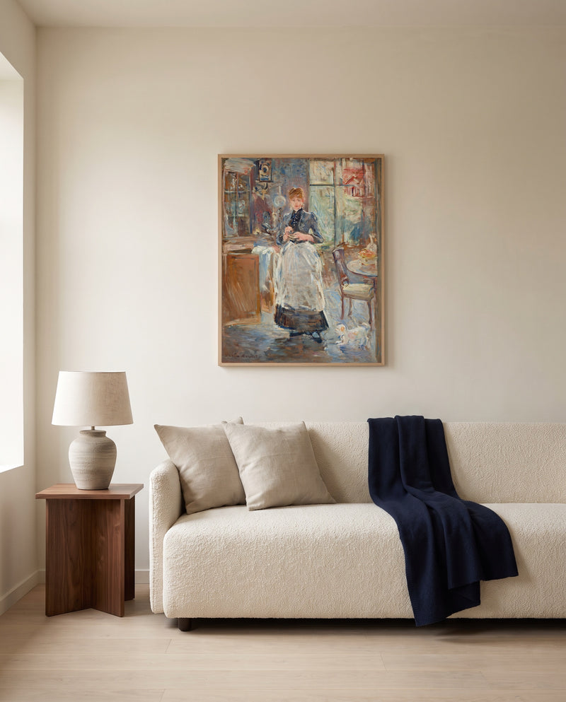 In the Dining Room by Berthe Morisot framed in natural oak above a cream sofa in a warm living room