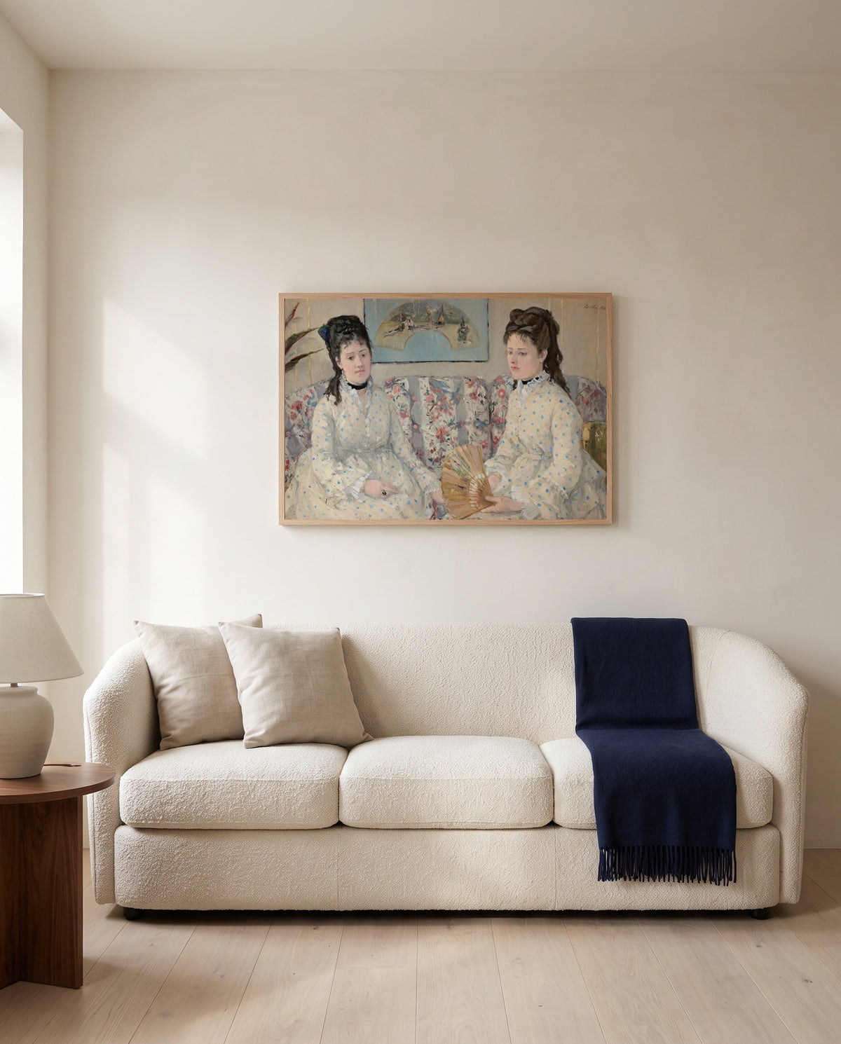 The Sisters by Berthe Morisot framed in natural oak above a cream sofa in a warm living room