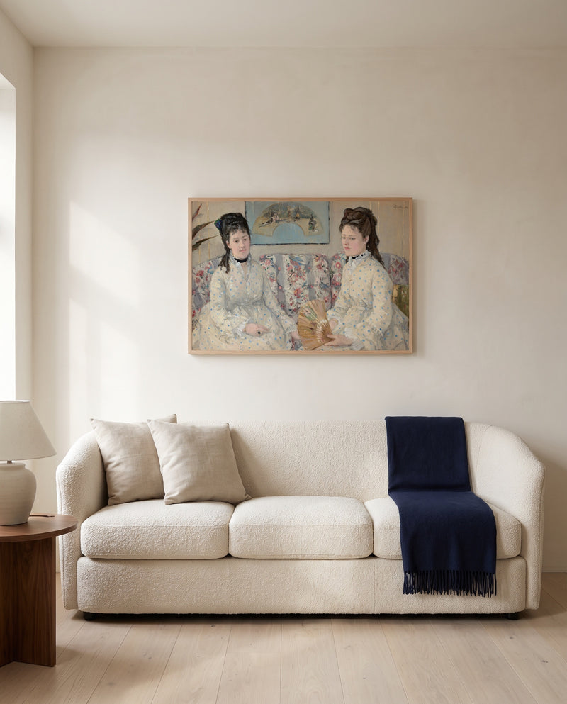 The Sisters by Berthe Morisot framed in natural oak above a cream sofa in a warm living room