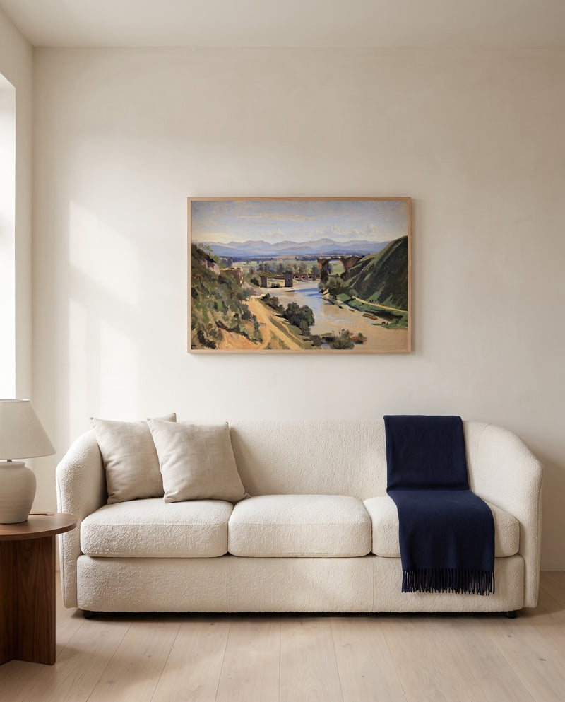 The Bridge at Narni by Camille Corot framed in natural oak above a cream sofa in a warm living room
