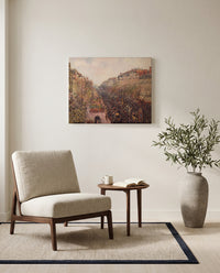 Boulevard Montmartre, Mardi Gras by Camille Pissarro as a stretched canvas above a linen lounge chair in a reading corner