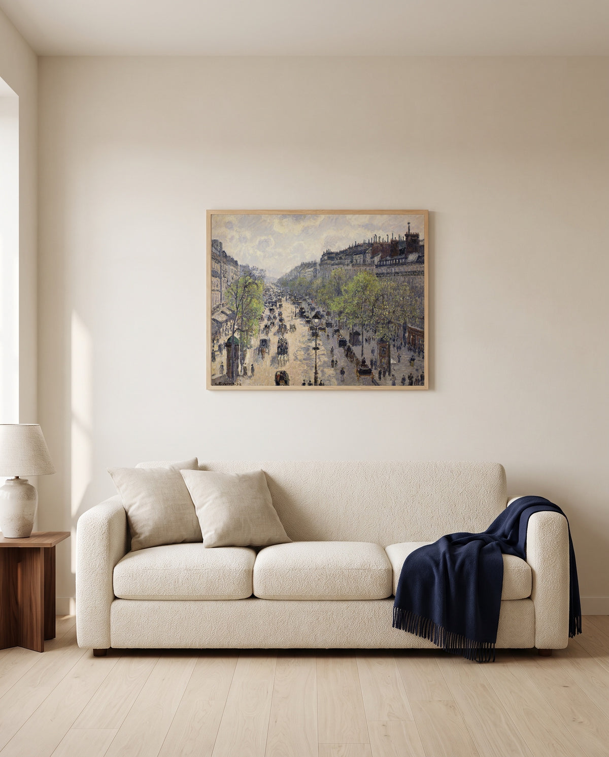 Boulevard Montmartre, Spring by Camille Pissarro framed in natural oak above a cream sofa in a warm living room