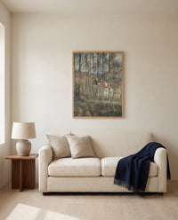 The Côte des Bœufs by Camille Pissarro framed in natural oak above a cream sofa in a warm living room