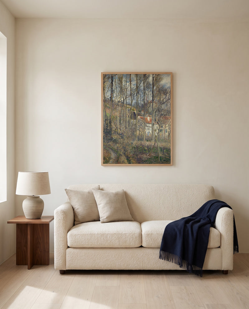 The Côte des Bœufs by Camille Pissarro framed in natural oak above a cream sofa in a warm living room