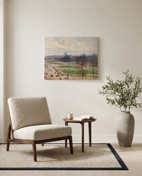 The Tuileries, Winter Afternoon by Camille Pissarro as a stretched canvas above a linen lounge chair in a reading corner