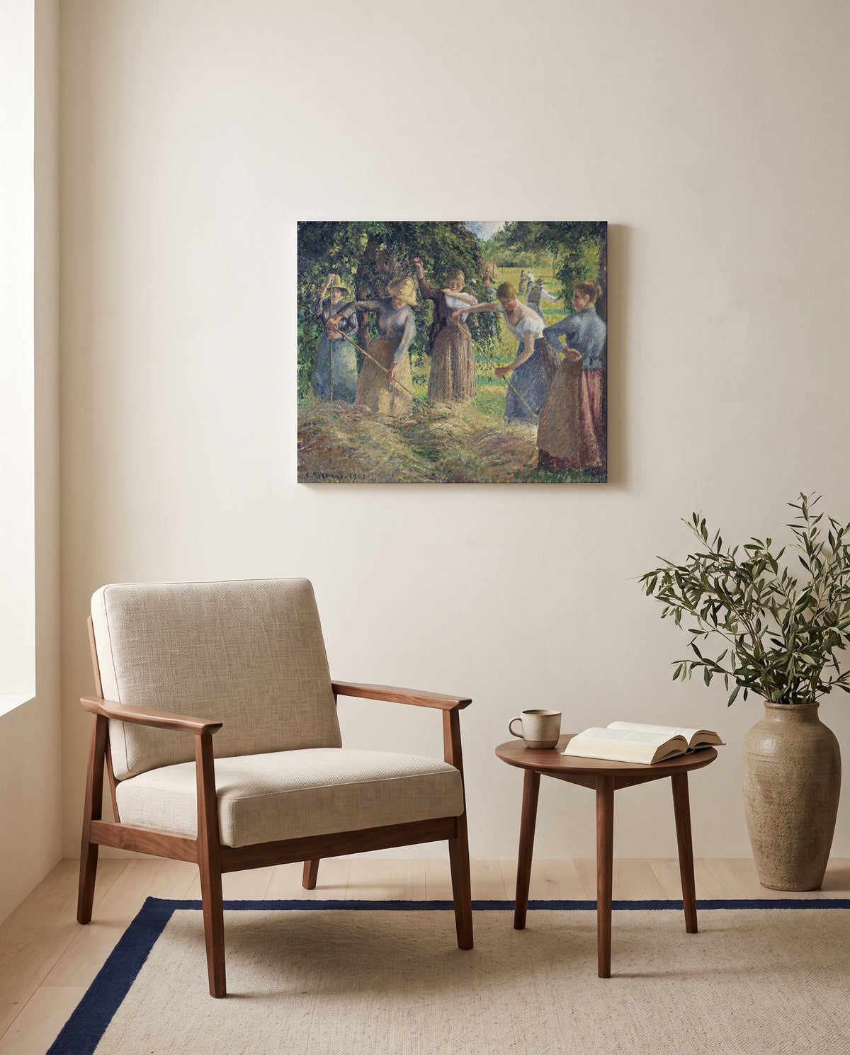 Hay Harvest at Éragny by Camille Pissarro as a stretched canvas above a linen lounge chair in a reading corner