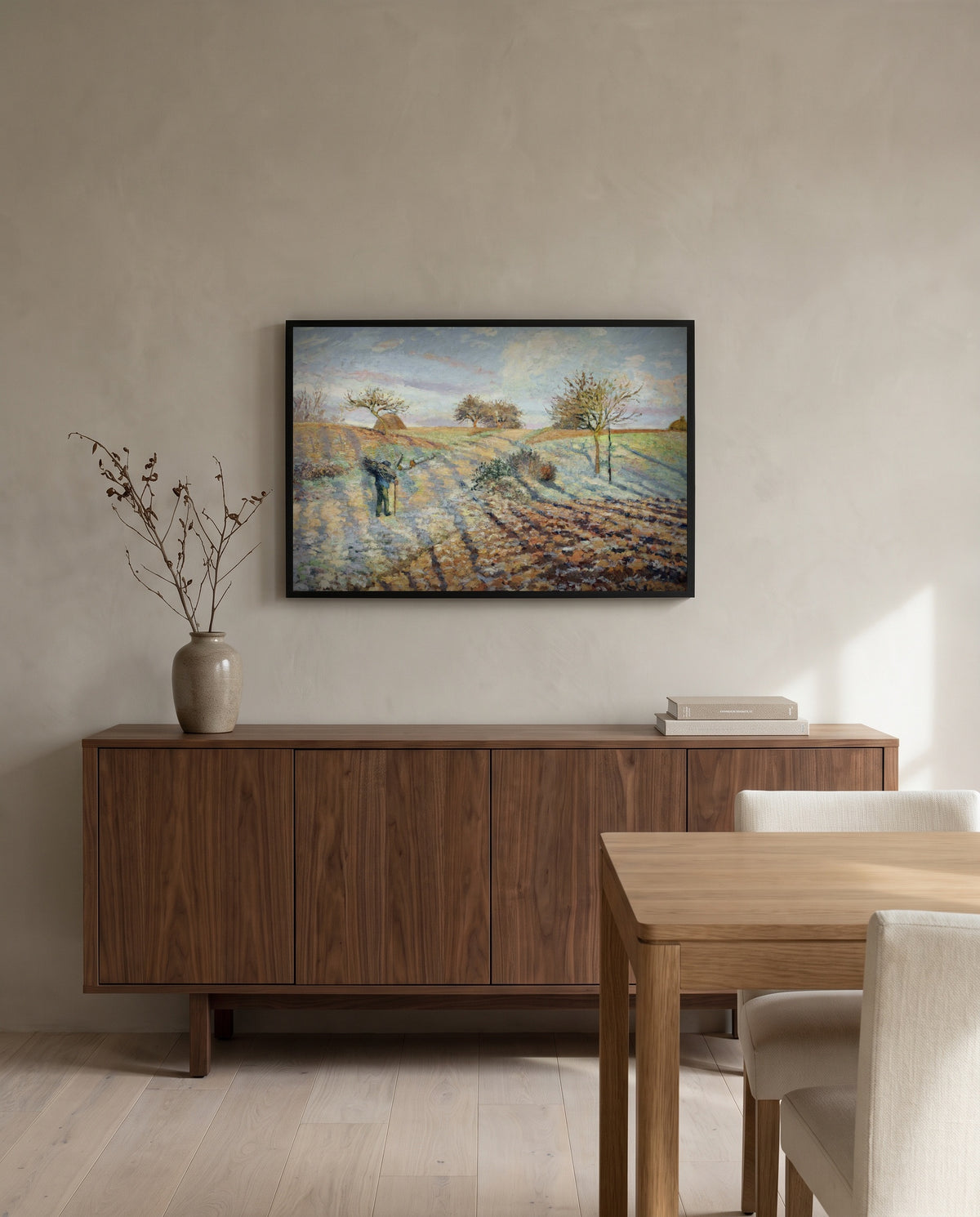 Hoarfrost by Camille Pissarro in a black frame above a walnut sideboard in a dining room