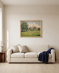 The House of the Deaf Woman by Camille Pissarro framed in natural oak above a cream sofa in a warm living room