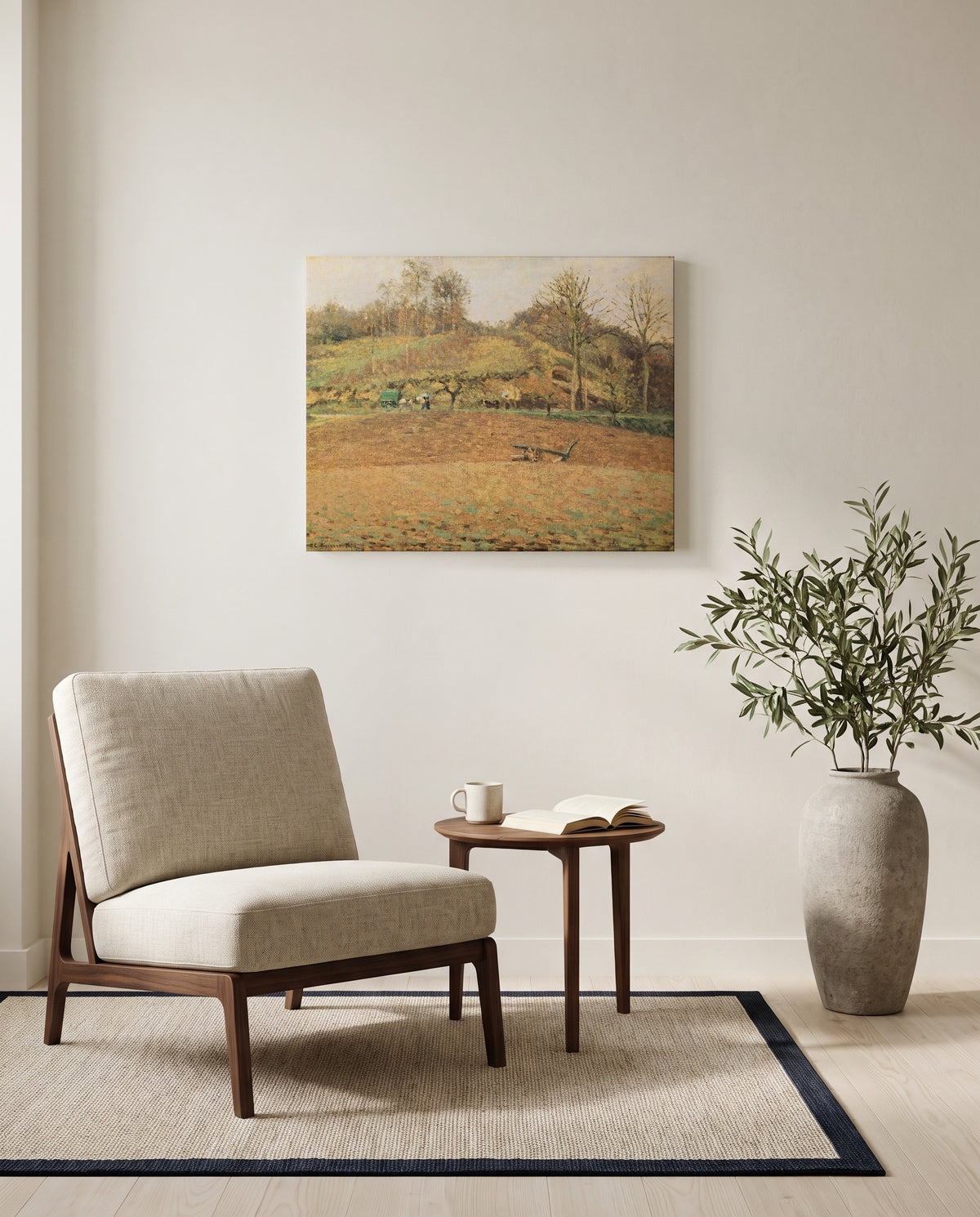 Ploughed Fields by Camille Pissarro as a stretched canvas above a linen lounge chair in a reading corner