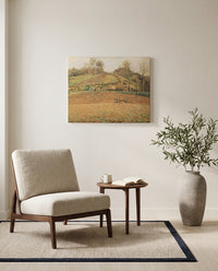 Ploughed Fields by Camille Pissarro as a stretched canvas above a linen lounge chair in a reading corner