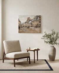 Road to Gisors, Winter by Camille Pissarro as a stretched canvas above a linen lounge chair in a reading corner