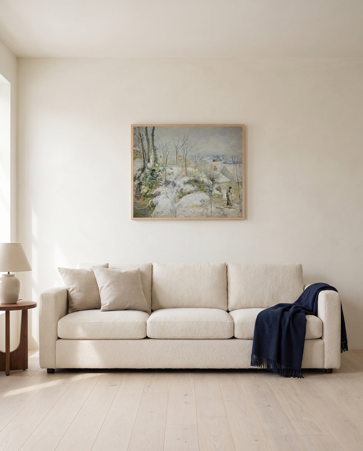 Rabbit Warren, Snow by Camille Pissarro framed in natural oak above a cream sofa in a warm living room