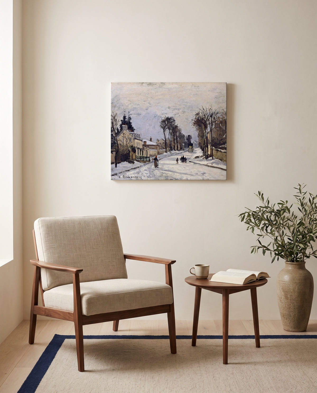 Route to Versailles by Camille Pissarro as a stretched canvas above a linen lounge chair in a reading corner