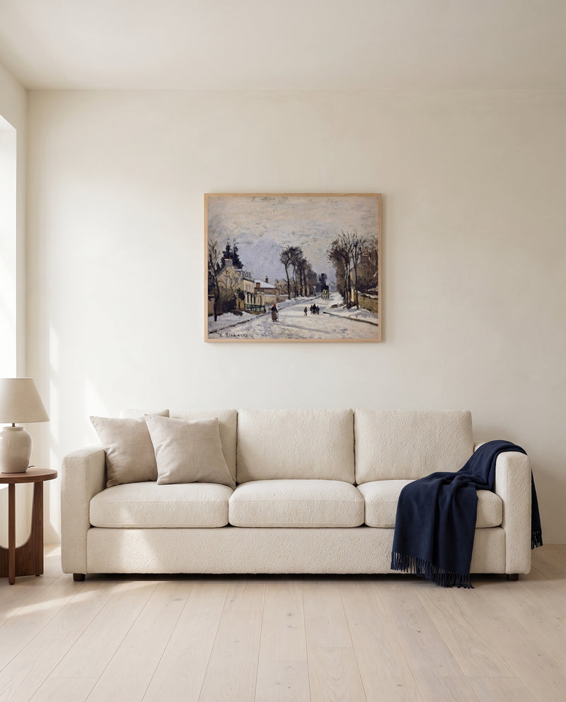 Route to Versailles by Camille Pissarro framed in natural oak above a cream sofa in a warm living room
