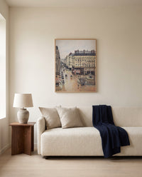 Rue Saint-Honoré, Effect of Rain by Camille Pissarro framed in natural oak above a cream sofa in a warm living room