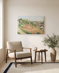 Ruelle des Poulies by Camille Pissarro as a stretched canvas above a linen lounge chair in a reading corner
