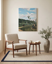 Strollers on a Country Road by Camille Pissarro as a stretched canvas above a linen lounge chair in a reading corner