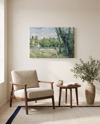 Sunlight on the Road by Camille Pissarro as a stretched canvas above a linen lounge chair in a reading corner