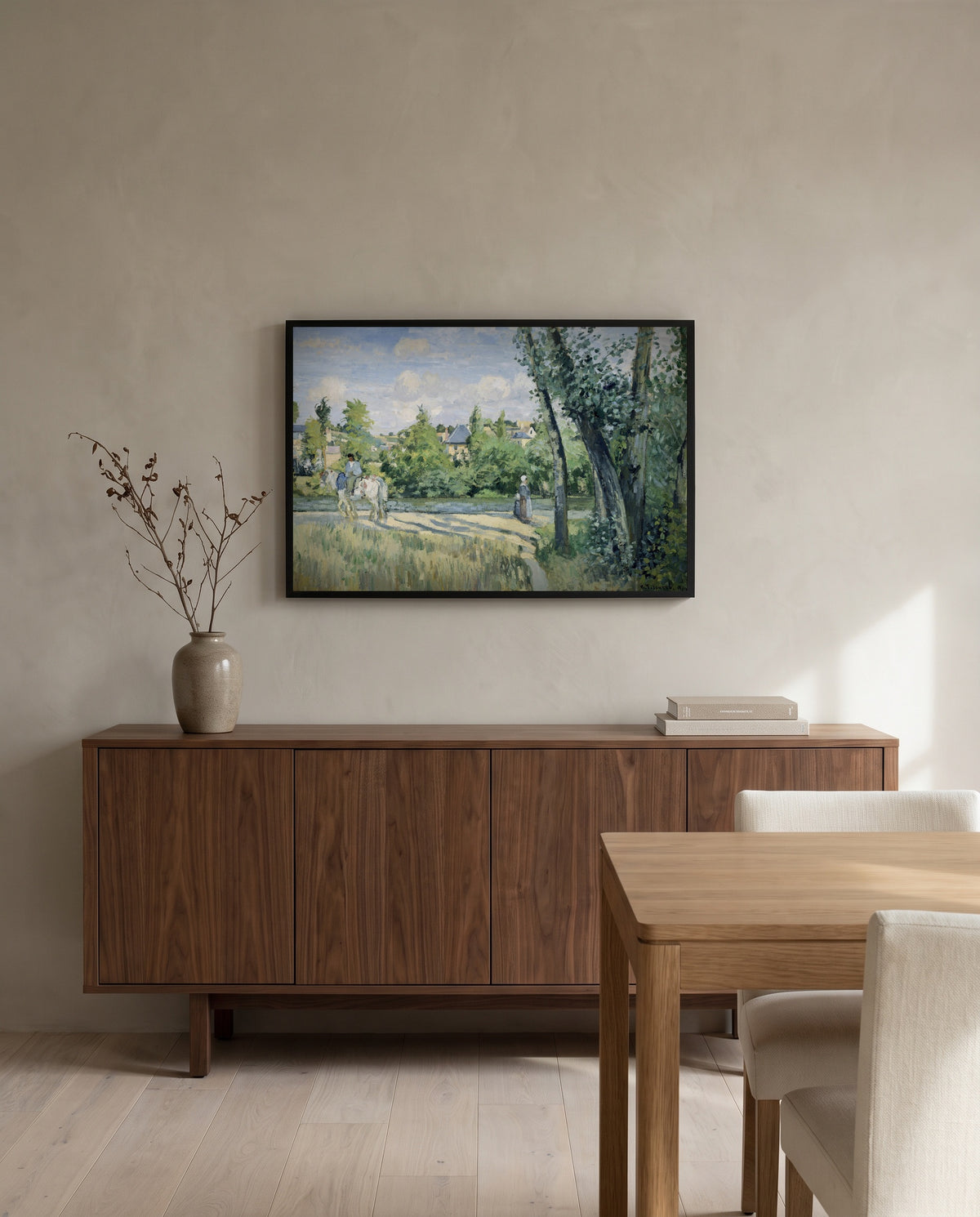 Sunlight on the Road by Camille Pissarro in a black frame above a walnut sideboard in a dining room