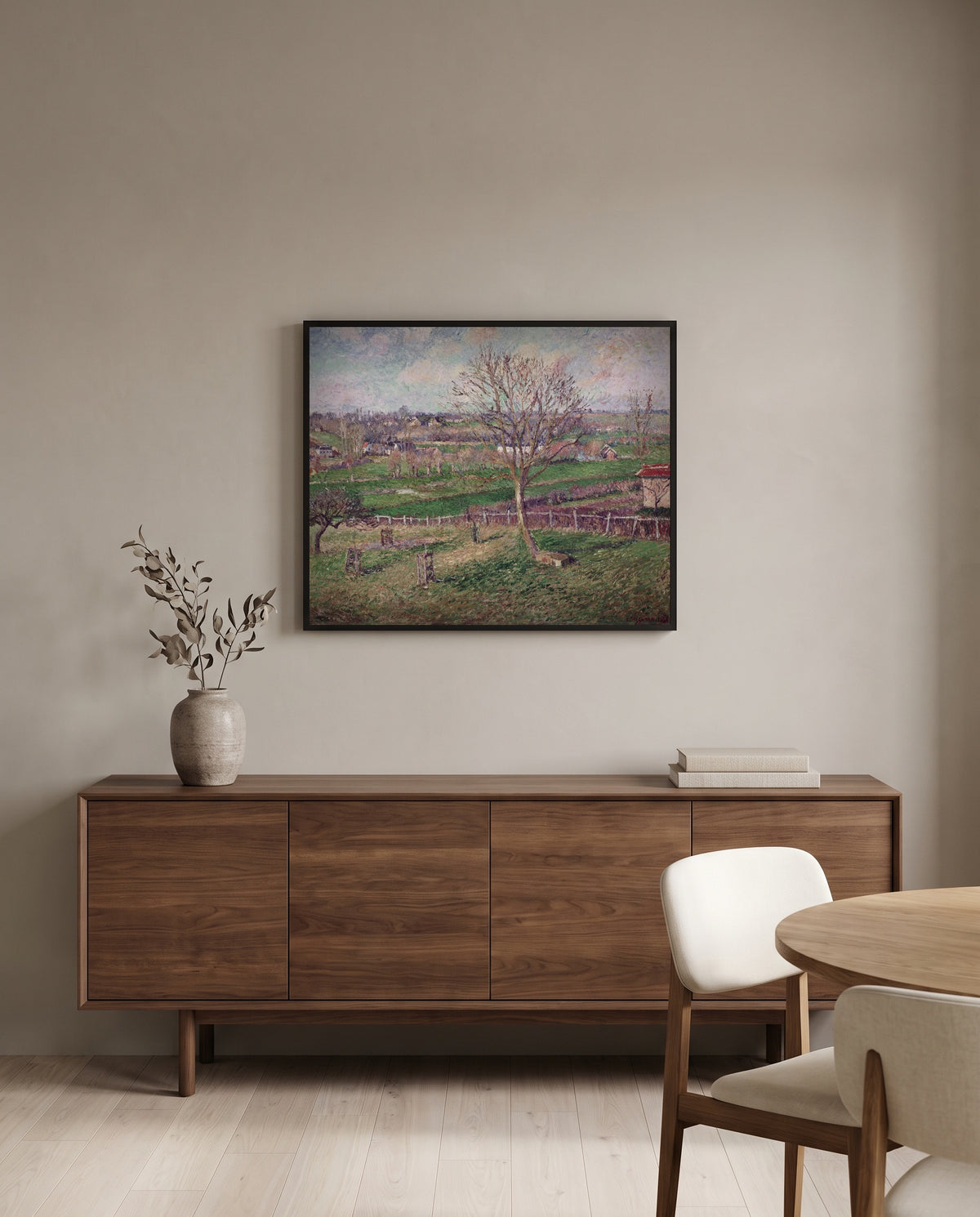 Walnut Tree in Winter by Camille Pissarro in a black frame above a walnut sideboard in a dining room