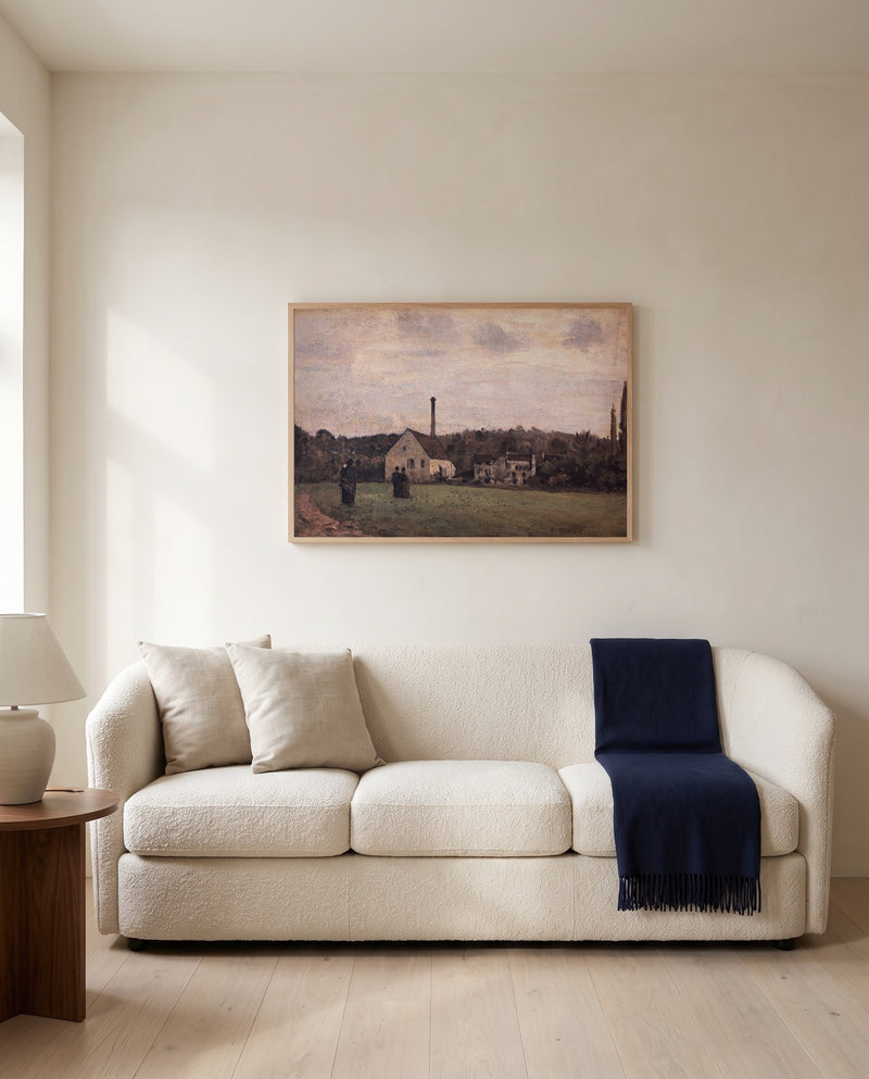 The Little Factory by Camille Pissarro framed in natural oak above a cream sofa in a warm living room