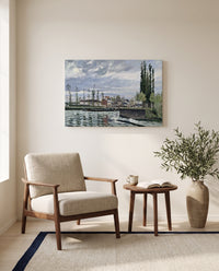 The Lock at Pontoise by Camille Pissarro as a stretched canvas above a linen lounge chair in a reading corner