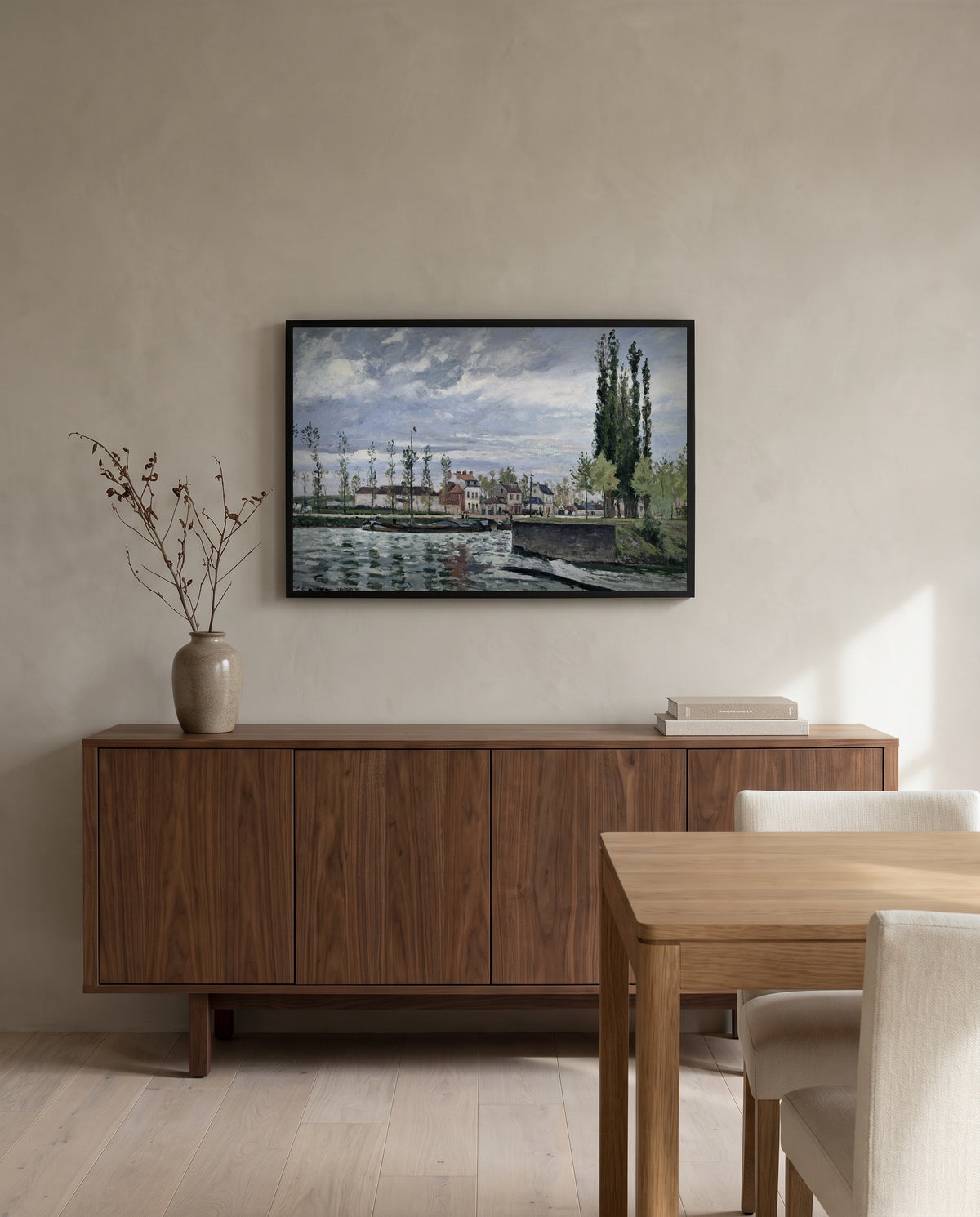 The Lock at Pontoise by Camille Pissarro in a black frame above a walnut sideboard in a dining room