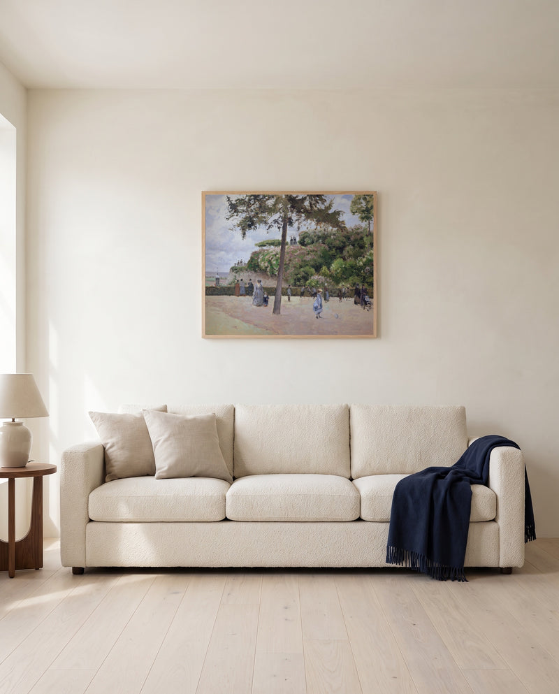 Public Garden, Pontoise by Camille Pissarro framed in natural oak above a cream sofa in a warm living room