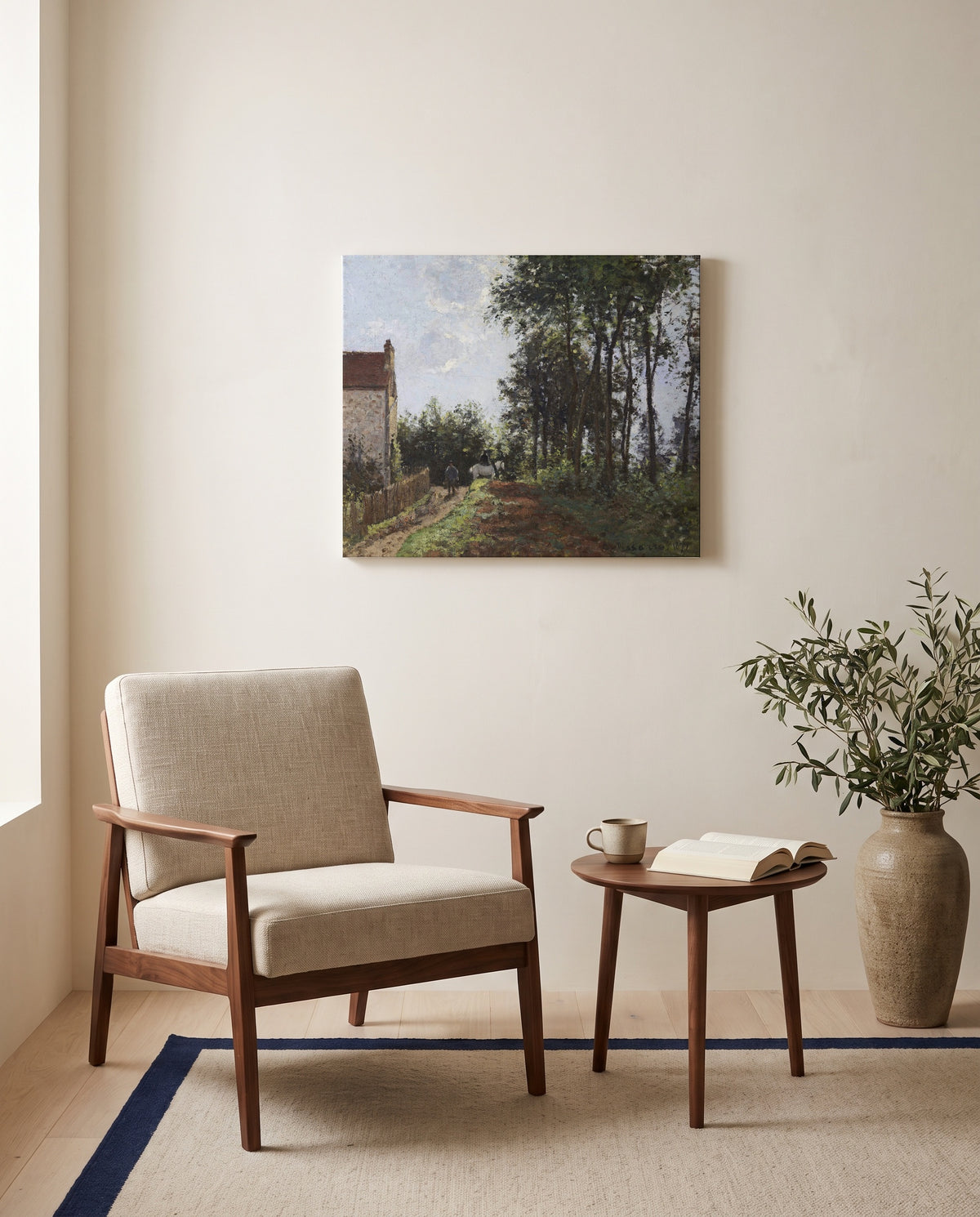 The Road Near the Farm by Camille Pissarro as a stretched canvas above a linen lounge chair in a reading corner
