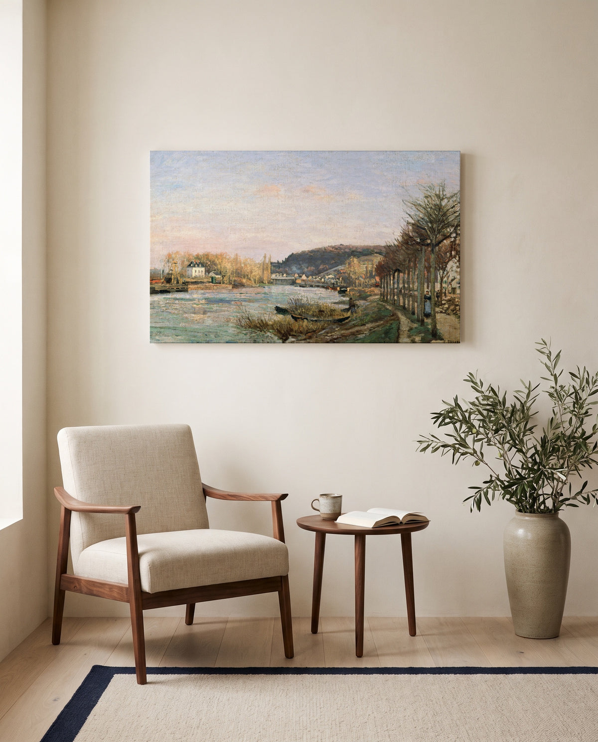 The Seine at Bougival by Camille Pissarro as a stretched canvas above a linen lounge chair in a reading corner
