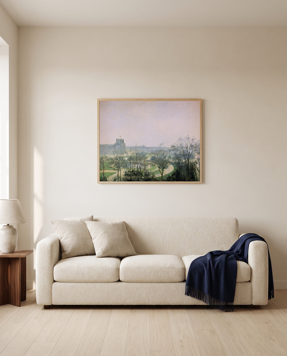 Tuileries Gardens by Camille Pissarro framed in natural oak above a cream sofa in a warm living room