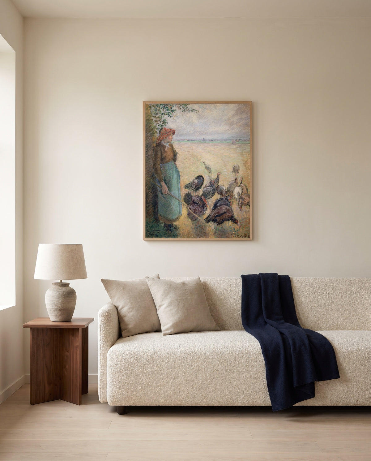 Turkey Girl by Camille Pissarro framed in natural oak above a cream sofa in a warm living room