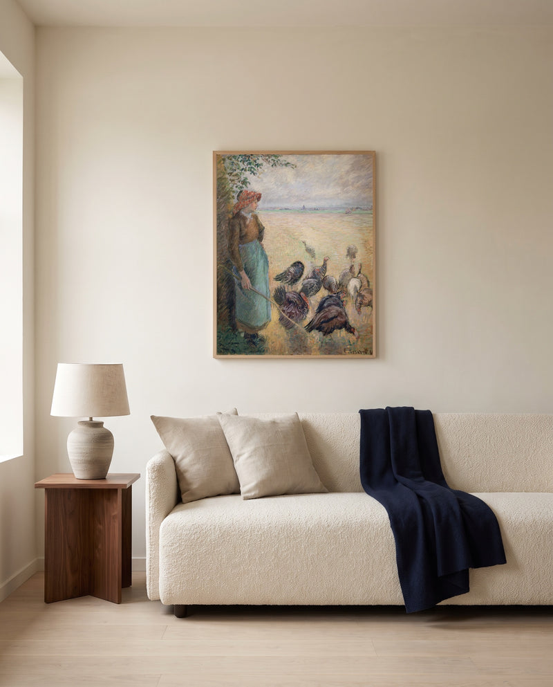 Turkey Girl by Camille Pissarro framed in natural oak above a cream sofa in a warm living room