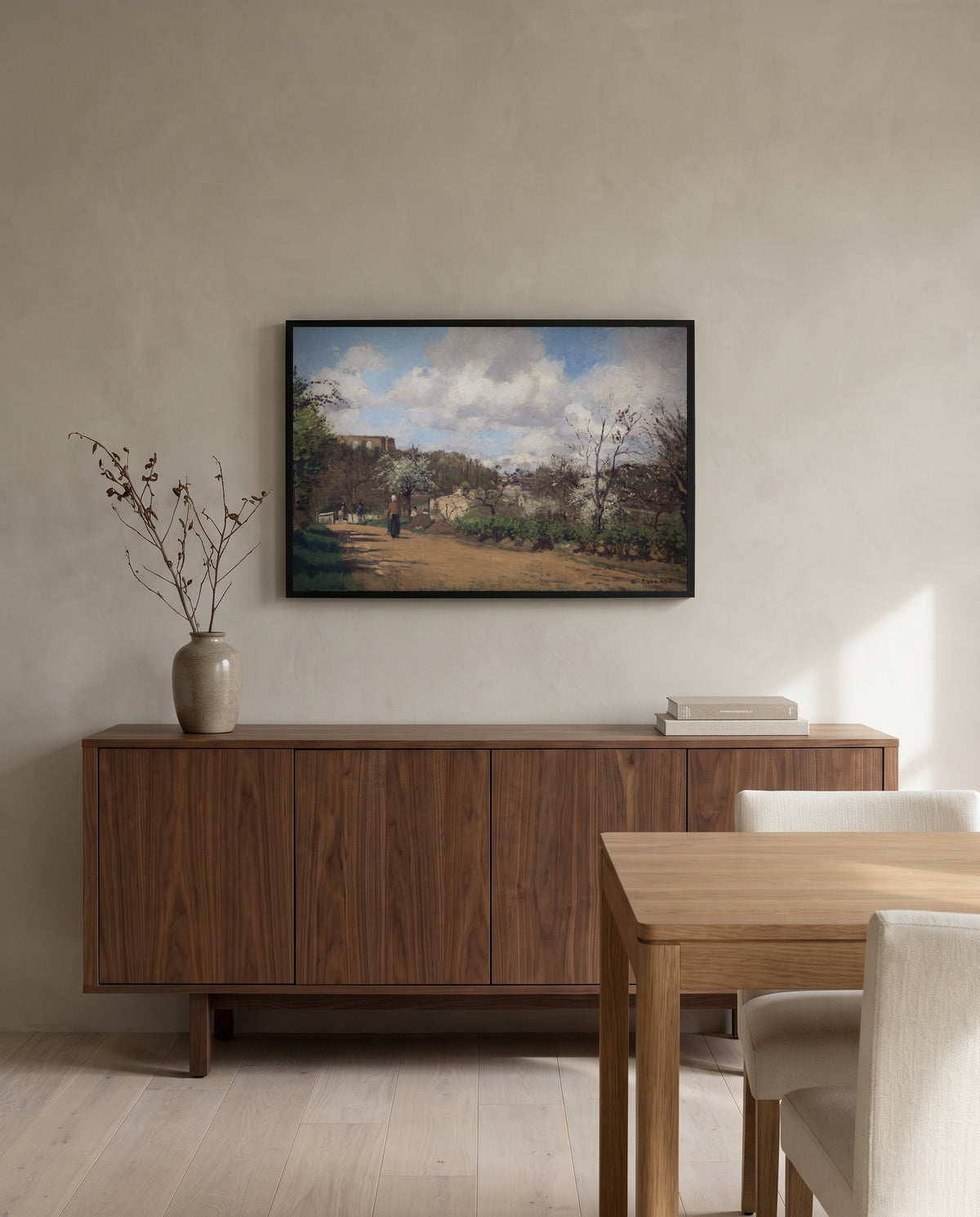 View from Louveciennes by Camille Pissarro in a black frame above a walnut sideboard in a dining room
