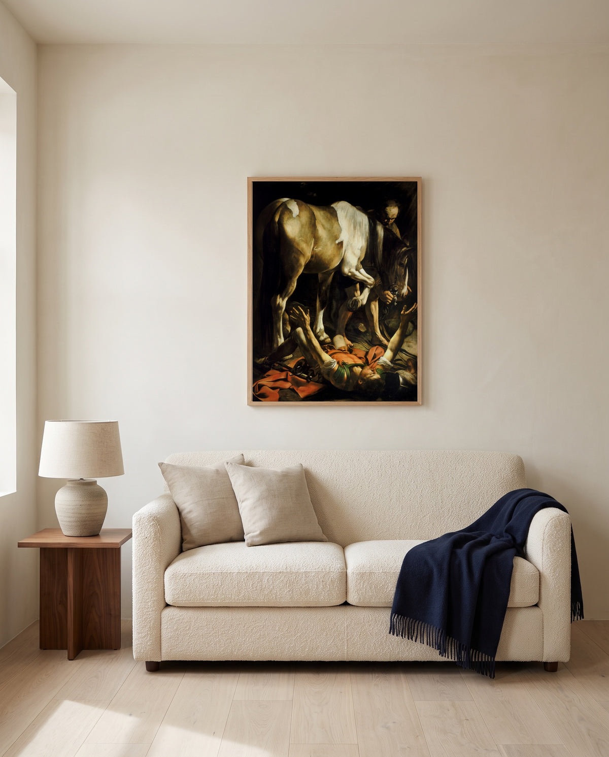 The Conversion of Saul by Caravaggio framed in natural oak above a cream sofa in a warm living room