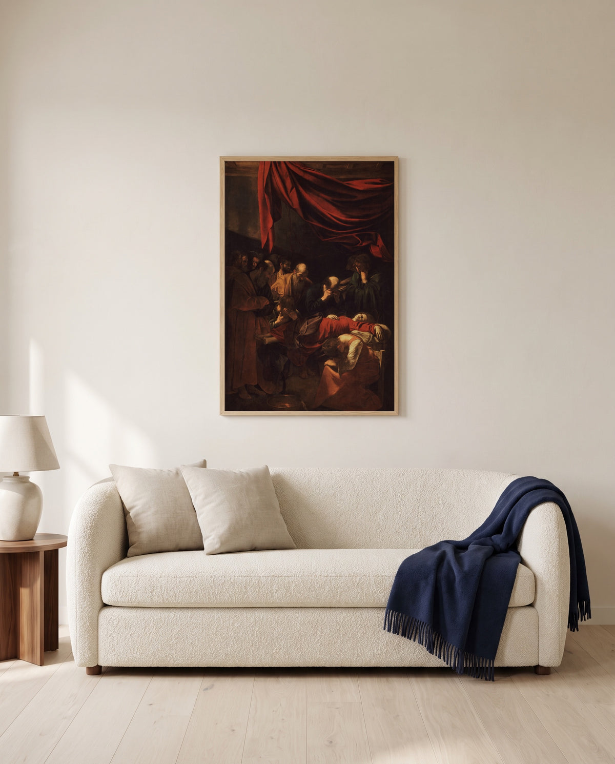 Death of the Virgin by Caravaggio framed in natural oak above a cream sofa in a warm living room