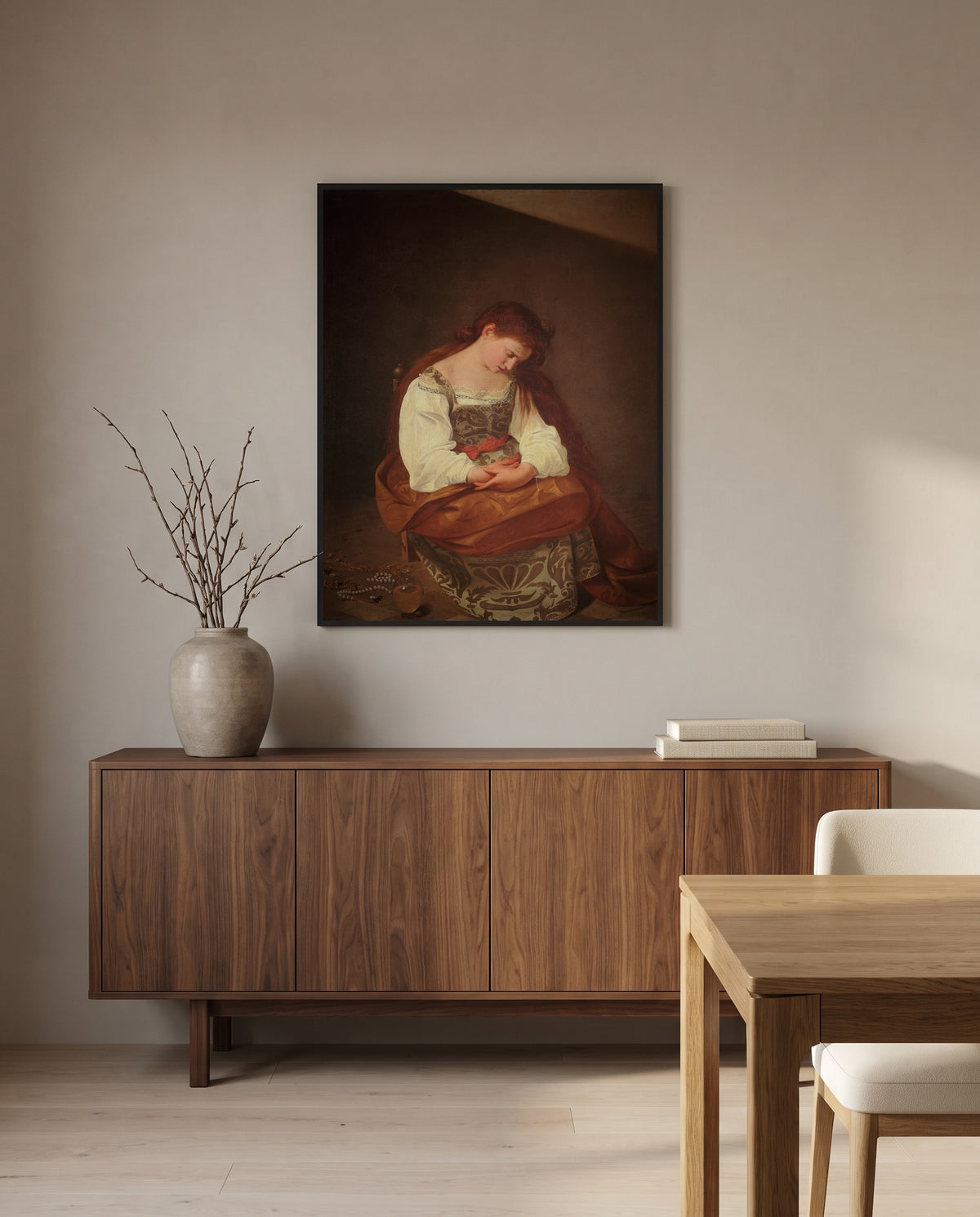 Penitent Magdalene by Caravaggio in a black frame above a walnut sideboard in a dining room