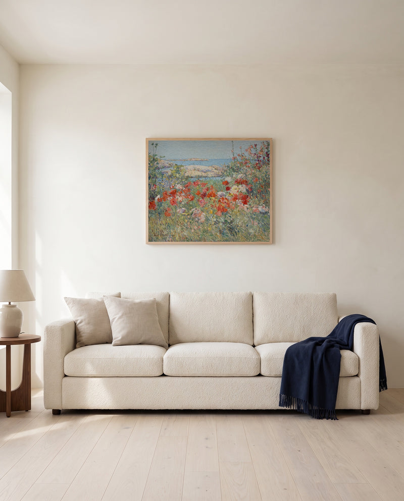 Celia Thaxter’s Garden by Childe Hassam framed in natural oak above a cream sofa in a warm living room