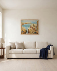 Coast Scene, Isles of Shoals by Childe Hassam framed in natural oak above a cream sofa in a warm living room