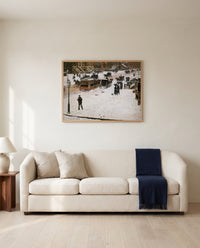 Fifth Avenue in Winter by Childe Hassam framed in natural oak above a cream sofa in a warm living room