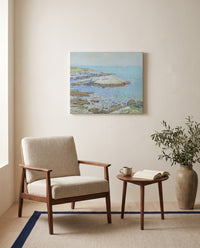 Isles of Shoals by Childe Hassam as a stretched canvas above a linen lounge chair in a reading corner