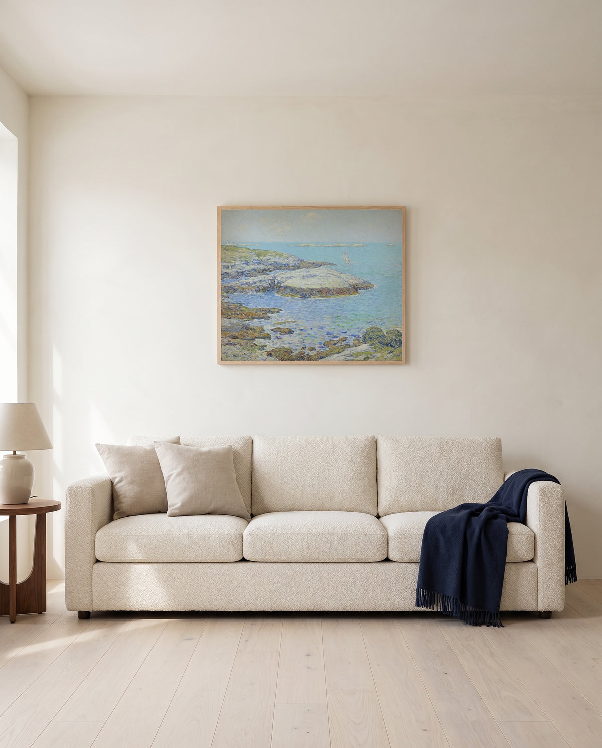 Isles of Shoals by Childe Hassam framed in natural oak above a cream sofa in a warm living room