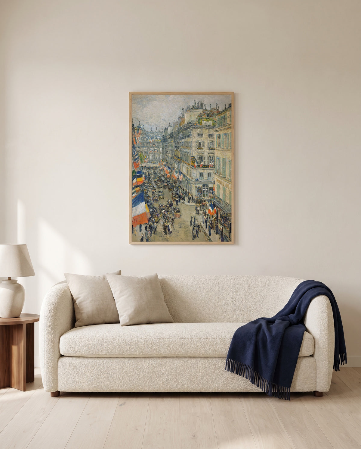 July Fourteenth, Rue Daunou by Childe Hassam framed in natural oak above a cream sofa in a warm living room