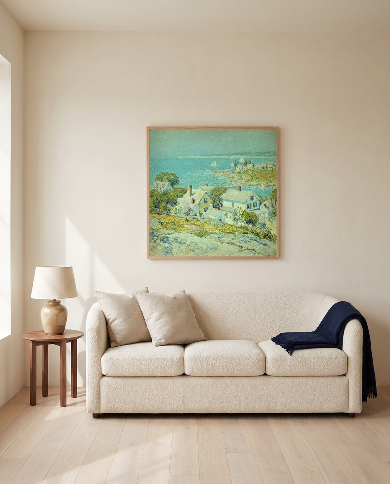 New England Headlands by Childe Hassam framed in natural oak above a cream sofa in a warm living room