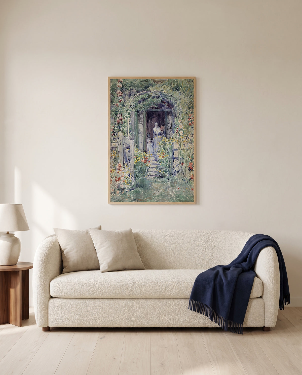 The Garden in Its Glory by Childe Hassam framed in natural oak above a cream sofa in a warm living room