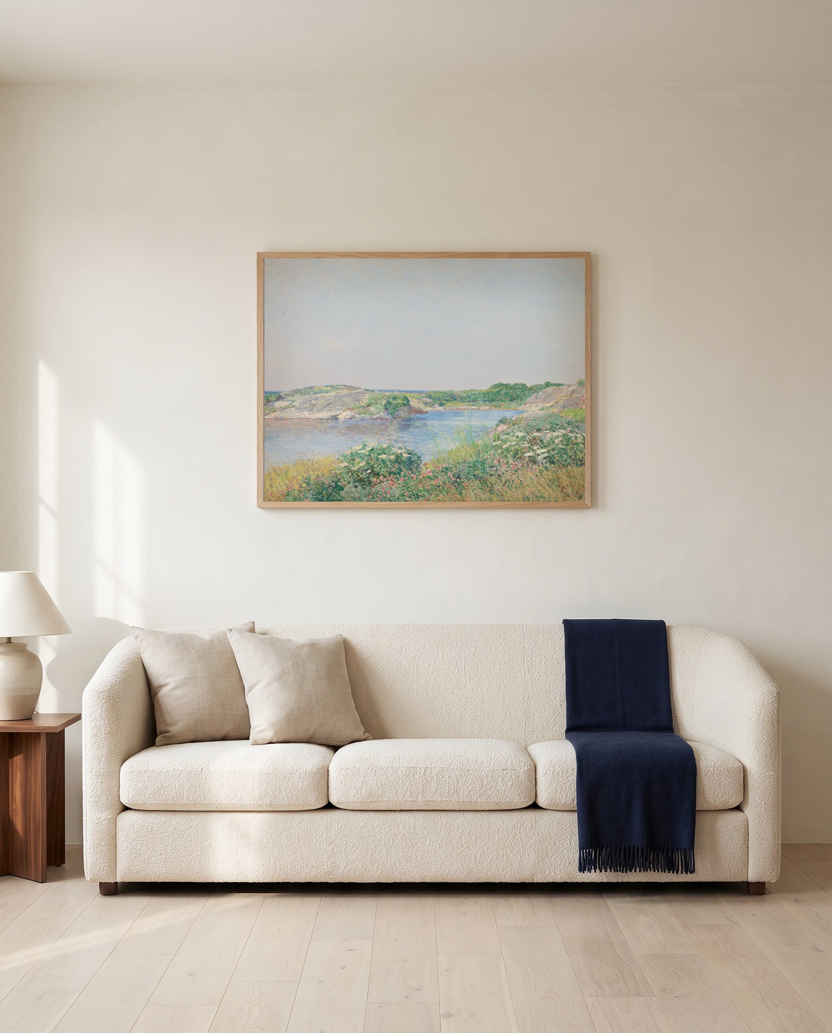 The Little Pond, Appledore by Childe Hassam framed in natural oak above a cream sofa in a warm living room