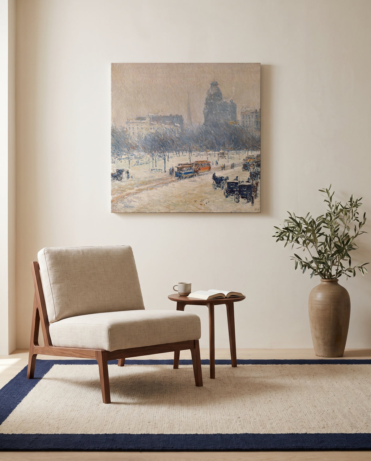 Winter in Union Square by Childe Hassam as a stretched canvas above a linen lounge chair in a reading corner