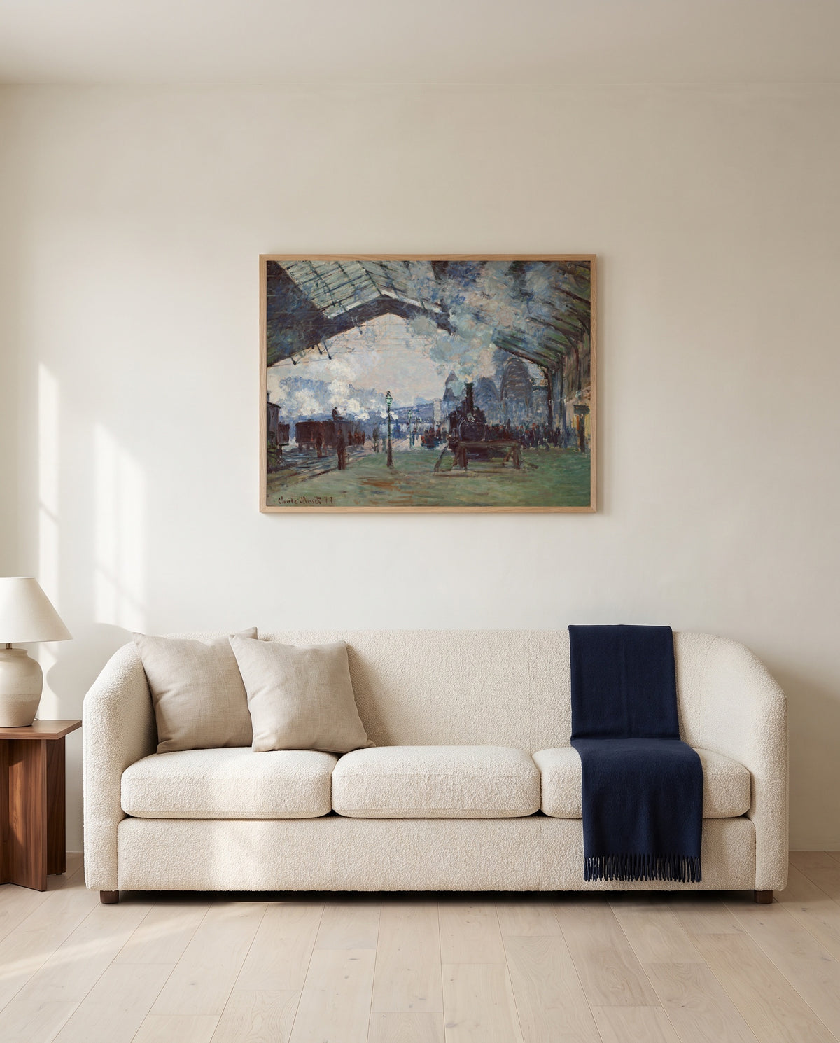 Arrival of the Normandy Train by Claude Monet framed in natural oak above a cream sofa in a warm living room