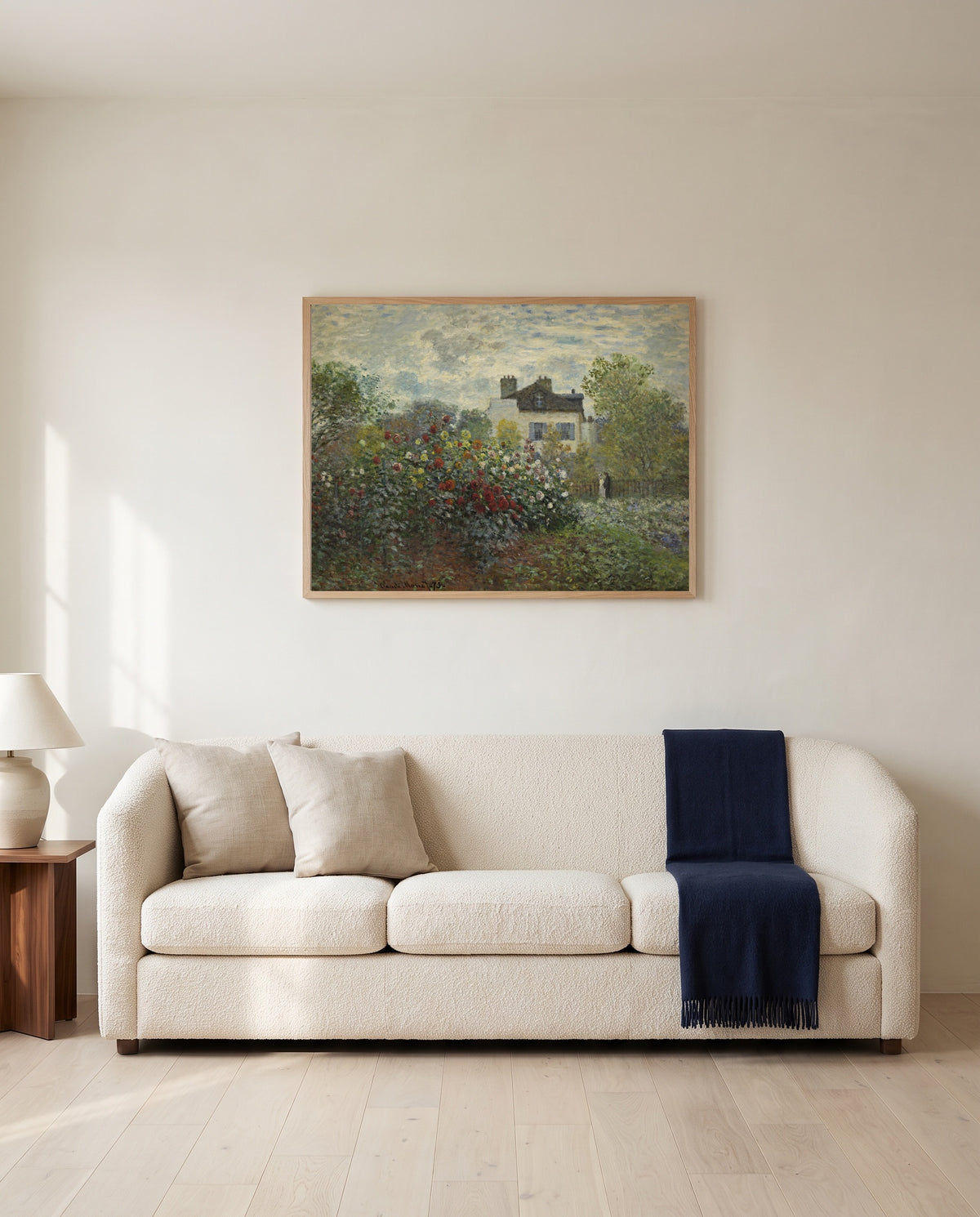 The Artist’s Garden in Argenteuil by Claude Monet framed in natural oak above a cream sofa in a warm living room