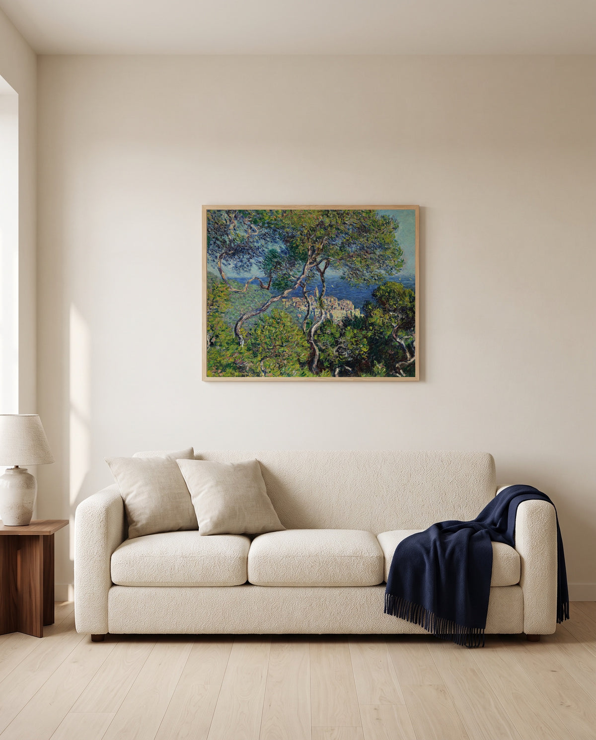 Bordighera by Claude Monet framed in natural oak above a cream sofa in a warm living room